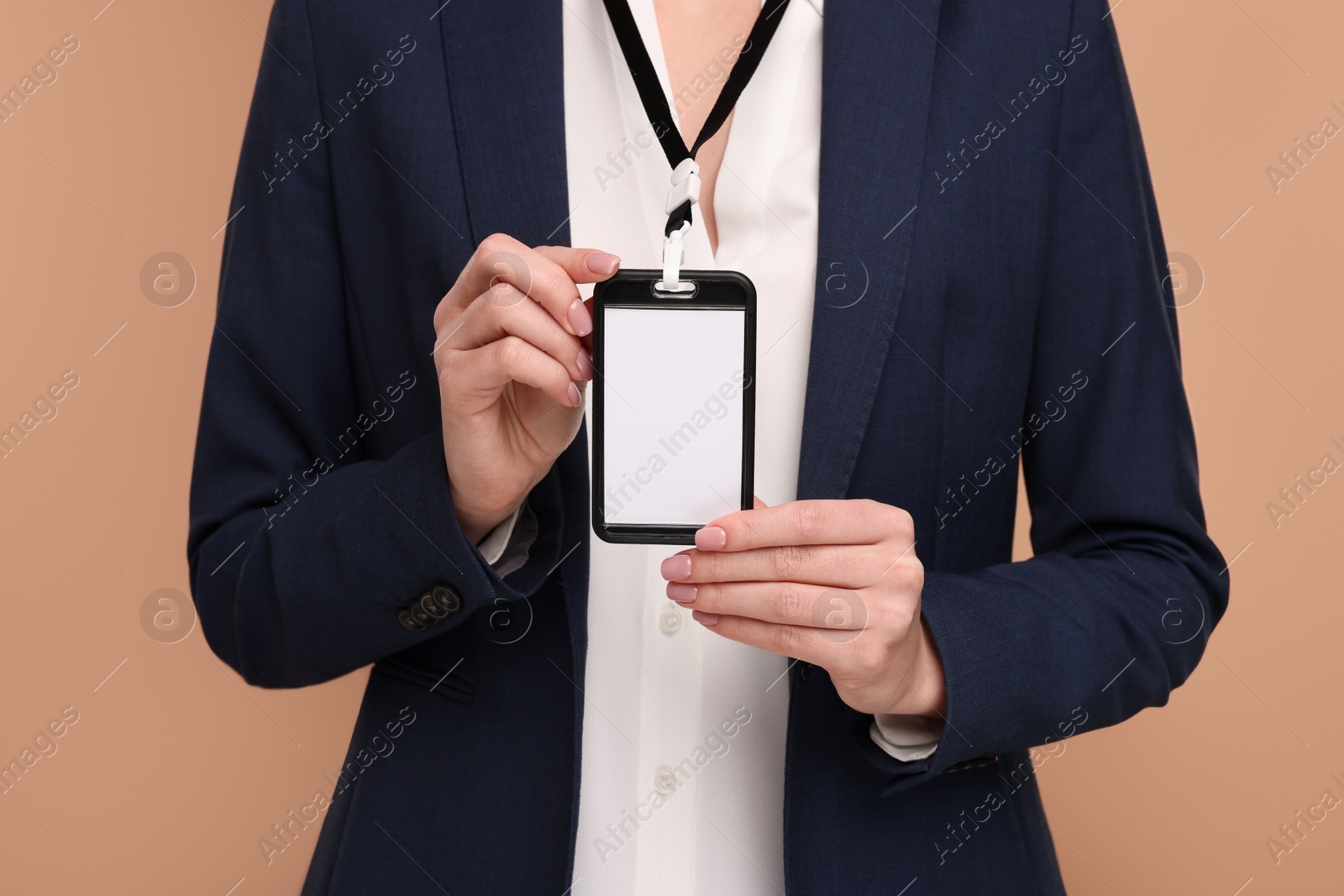 Photo of Woman with blank badge on light brown background, closeup