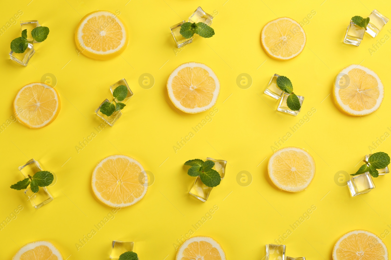 Photo of Lemonade layout with juicy lemon slices, ice and mint on yellow background, top view