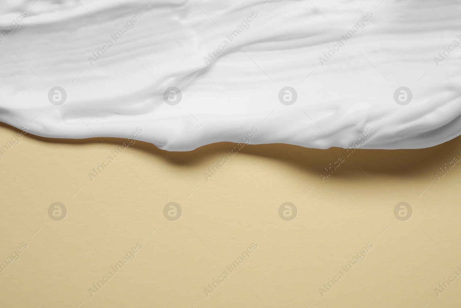 Photo of Sample of shaving foam on beige background, top view. Space for text
