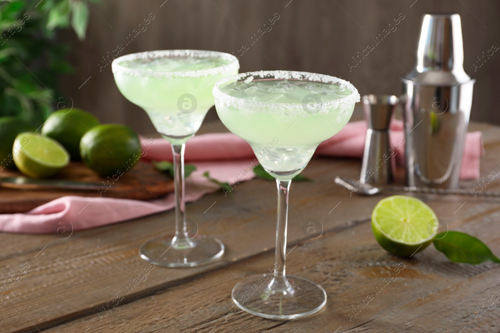 Photo of Delicious Margarita cocktail in glasses on wooden table, closeup