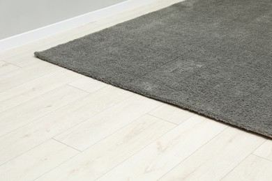 Photo of Soft grey carpet on white laminated floor indoors, space for text