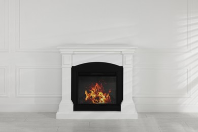 Modern electric fireplace near white wall in room