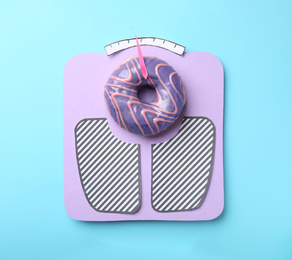 Photo of Scales made with donut on light blue background, top view