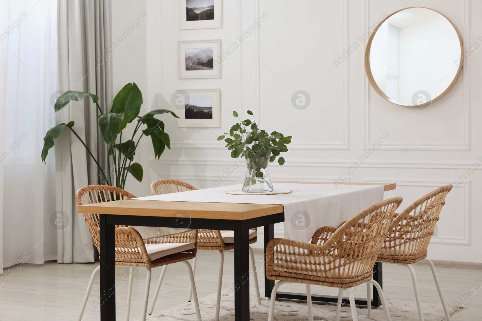 Photo of Stylish dining room with cozy furniture, mirror and plants