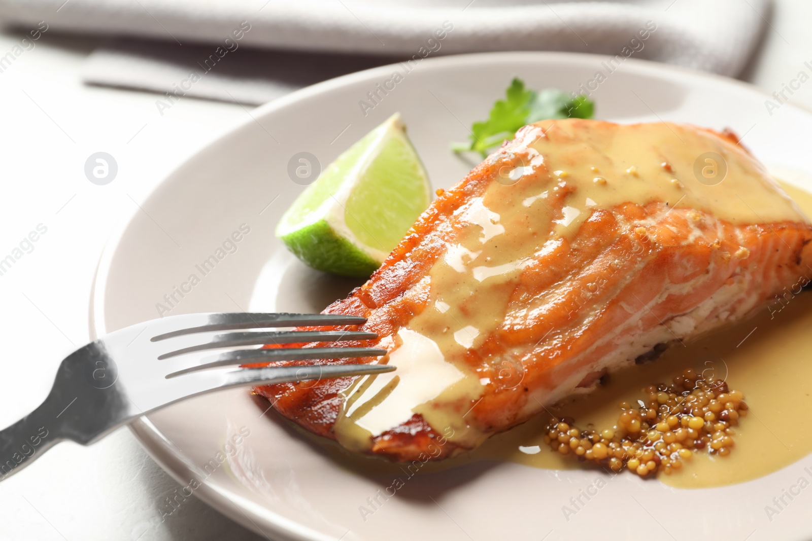 Photo of Tasty cooked salmon with mustard on plate, closeup