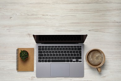 Modern laptop, houseplant, notebook and cup of coffee on white wooden table, flat lay. Space for text