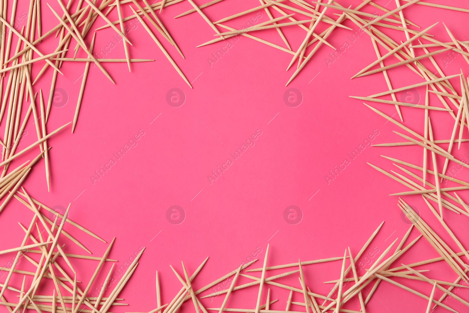 Photo of Frame of wooden toothpicks on pink background, flat lay. Space for text