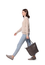 Photo of Happy young woman with stylish bag walking on white background