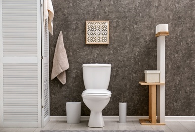 Photo of Toilet bowl near dark wall in modern bathroom interior