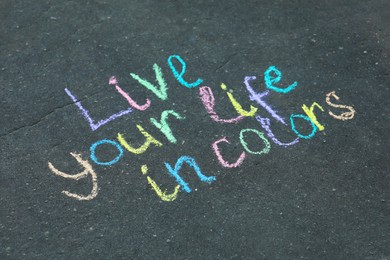 Photo of Phrase Live Your Life In Colors written on asphalt