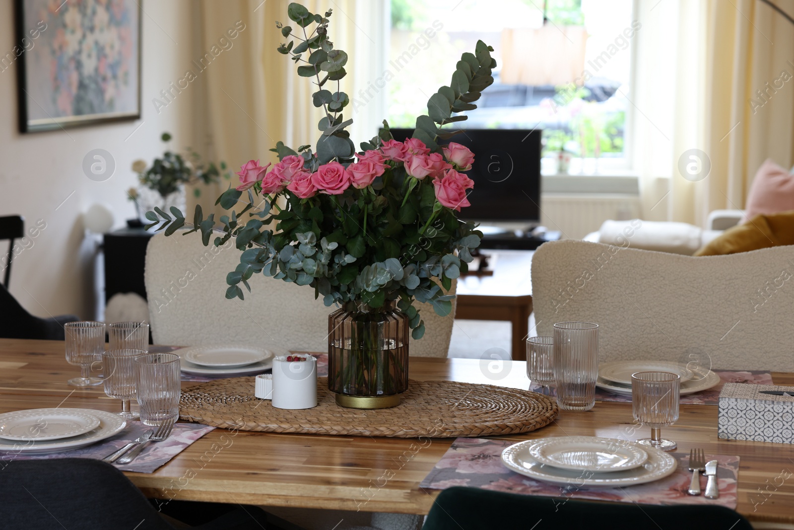 Photo of Beautiful table setting with bouquet of roses, napkins and candles in room