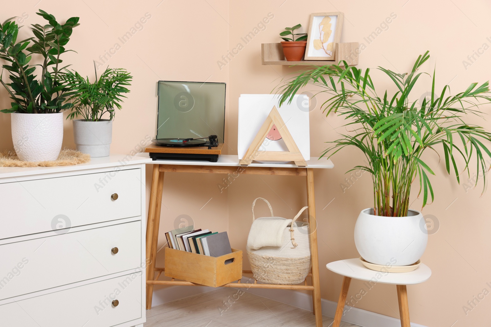 Photo of Stylish turntable with vinyl record on console table in cozy room