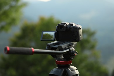 Photo of Taking photo of beautiful landscape with camera mounted on tripod outdoors