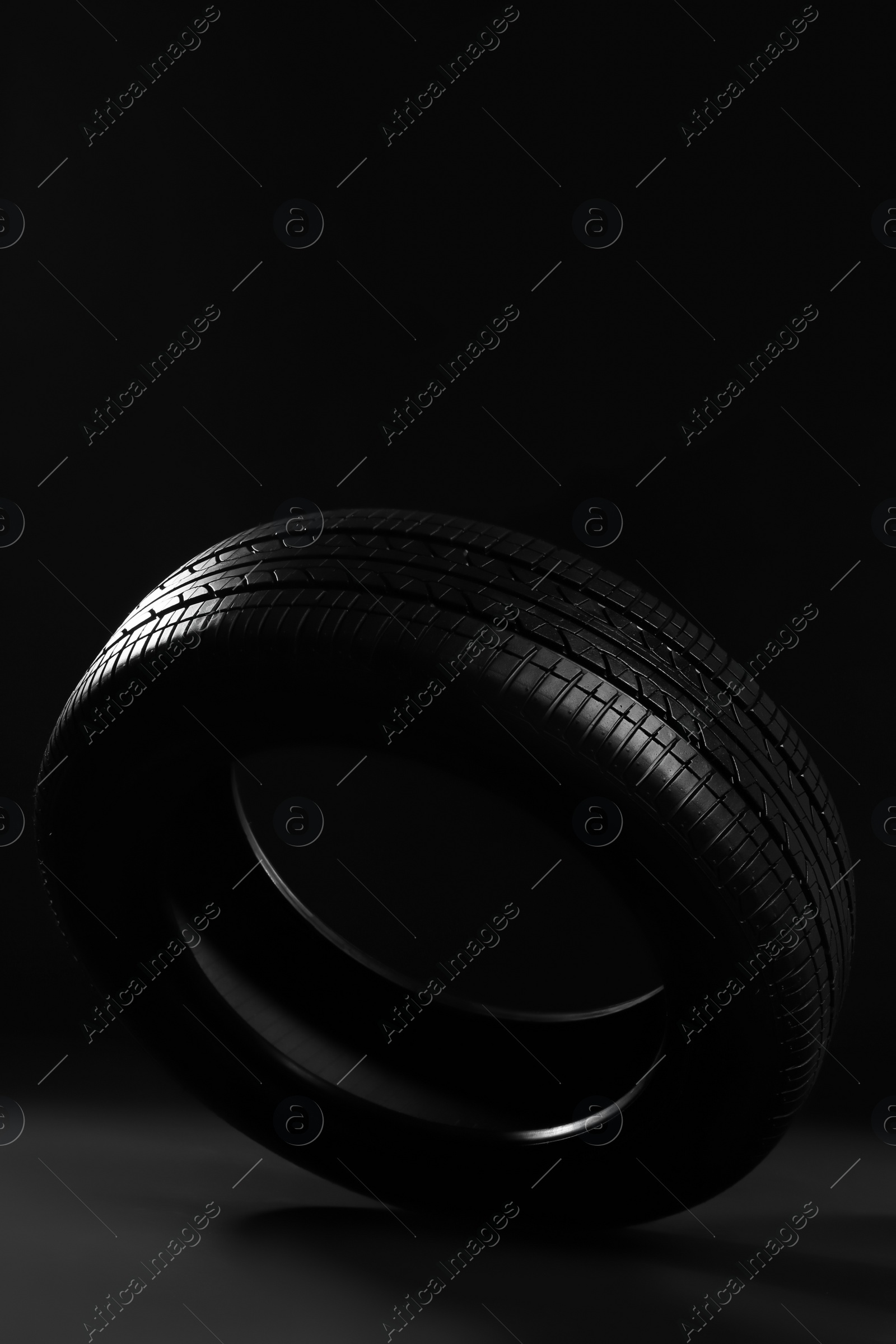 Photo of New car tire on black background