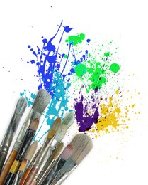 Image of Different brushes and paint splatters on white background
