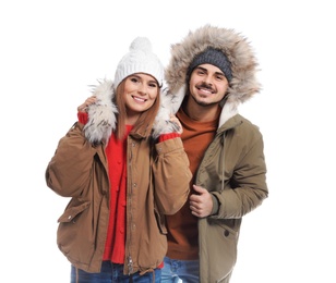 Young couple wearing warm clothes on white background. Ready for winter vacation