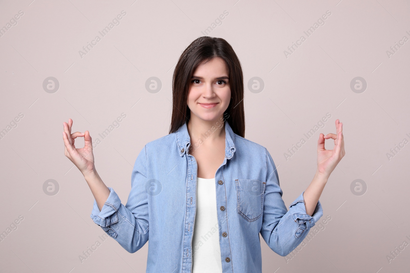 Photo of Young woman meditating on light background. Stress relief exercise