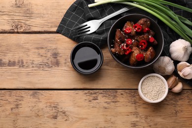 Tasty roasted meat, soy sauce and products on wooden table, flat lay. Space for text