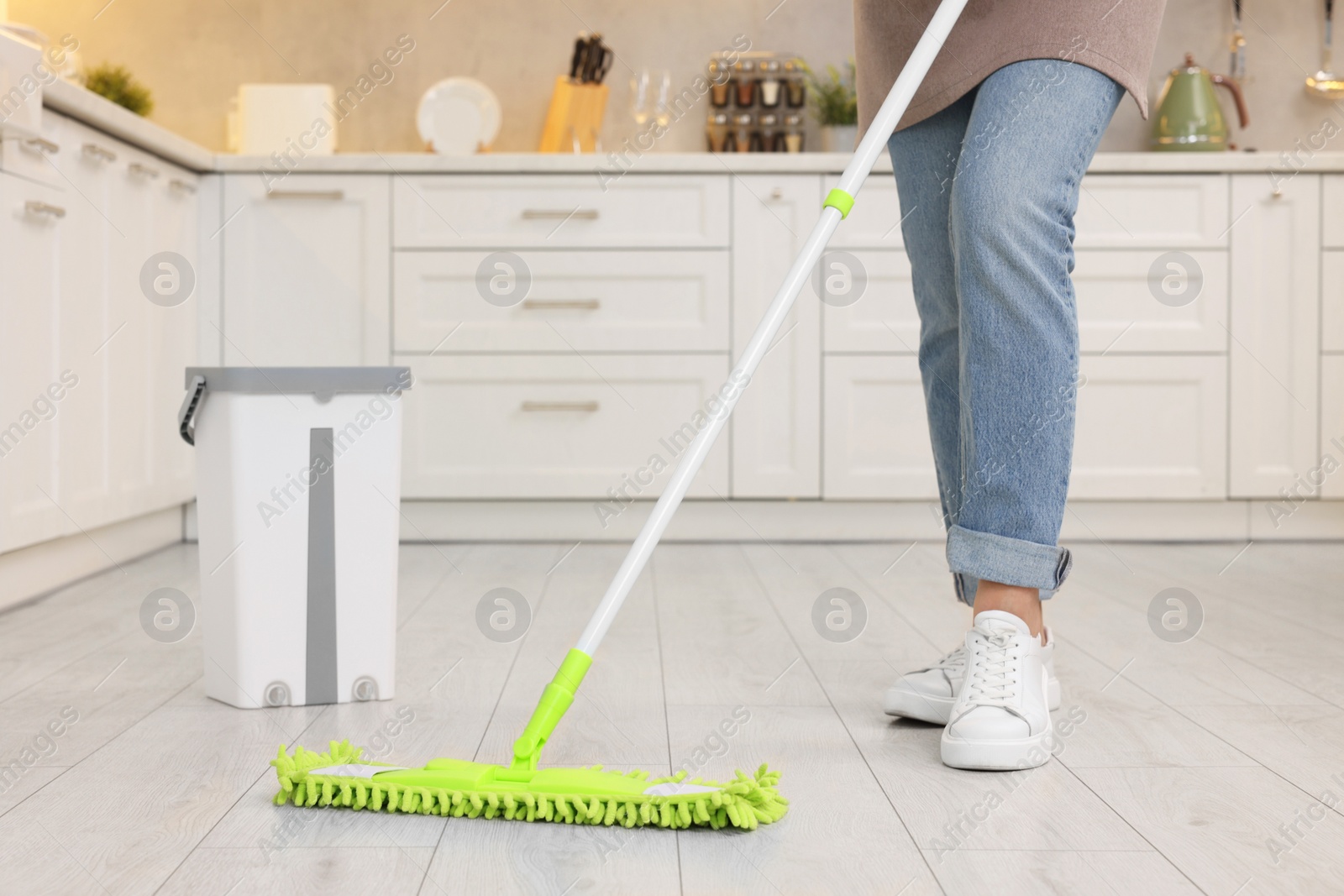 Photo of Woman cleaning floor with mop indoors, closeup