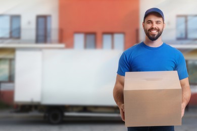 Happy courier with parcel outdoors, space for text