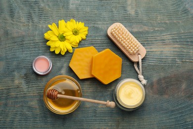 Photo of Flat lay composition with beeswax and cosmetic products on blue wooden table