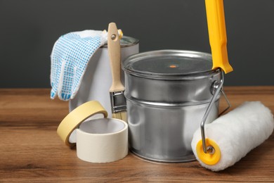 Cans of orange paint and renovation equipment on wooden table