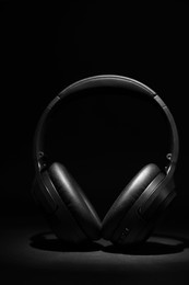 Stylish modern wireless headphones on black background