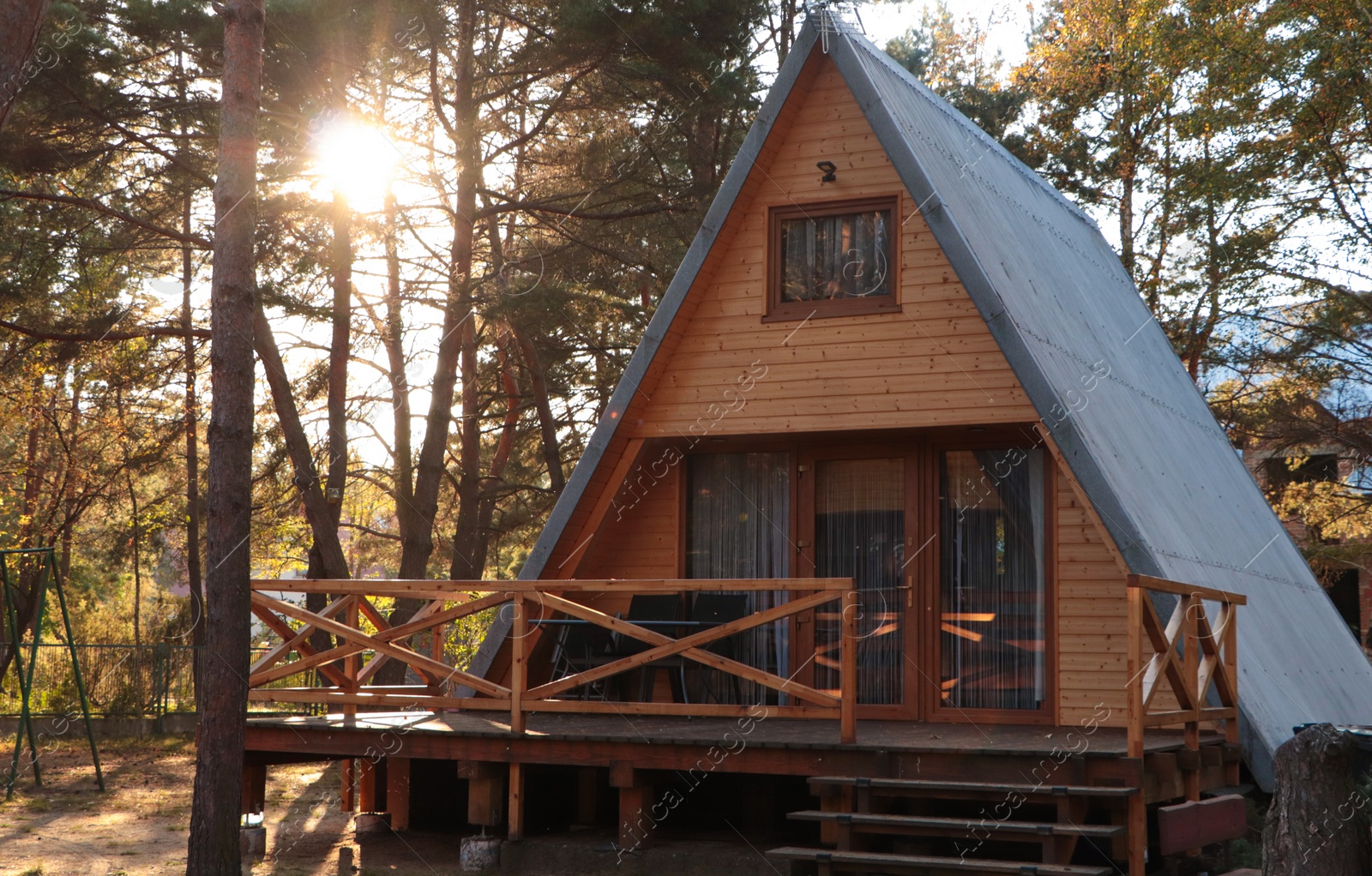 Photo of Picturesque view of modern wooden house with veranda near forest on sunny day