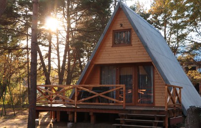 Photo of Picturesque view of modern wooden house with veranda near forest on sunny day