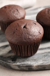 Photo of Delicious fresh chocolate cupcakes on grey marble board, closeup