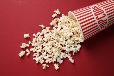 Photo of Delicious popcorn on red background, above view