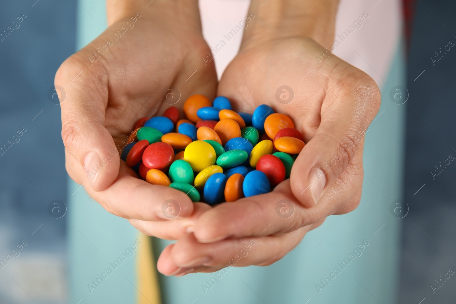 Photo of Woman holding many tasty glazed candies, closeup