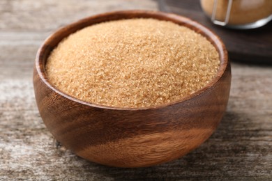 Photo of Brown sugar in bowl on wooden table, closeup