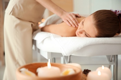 Photo of Young woman having massage in spa salon