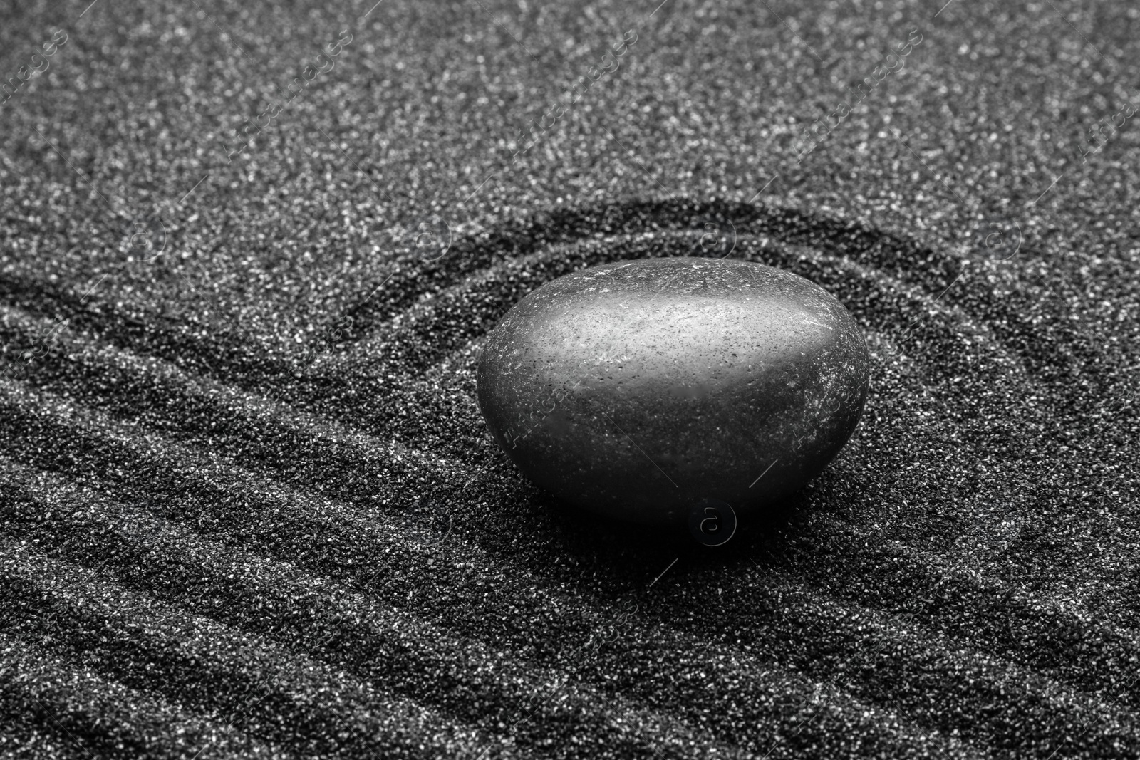Photo of Black sand with stone and beautiful pattern. Zen concept