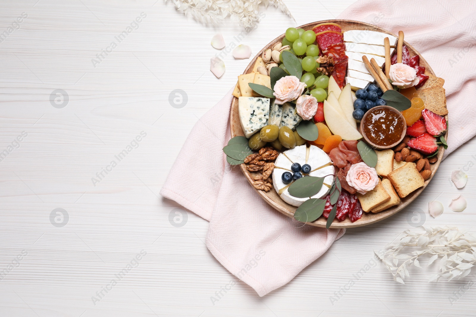 Photo of Assorted appetizers served on white wooden table, flat lay. Space for text