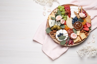 Photo of Assorted appetizers served on white wooden table, flat lay. Space for text
