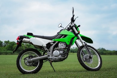 Stylish cross motorcycle on green grass outdoors