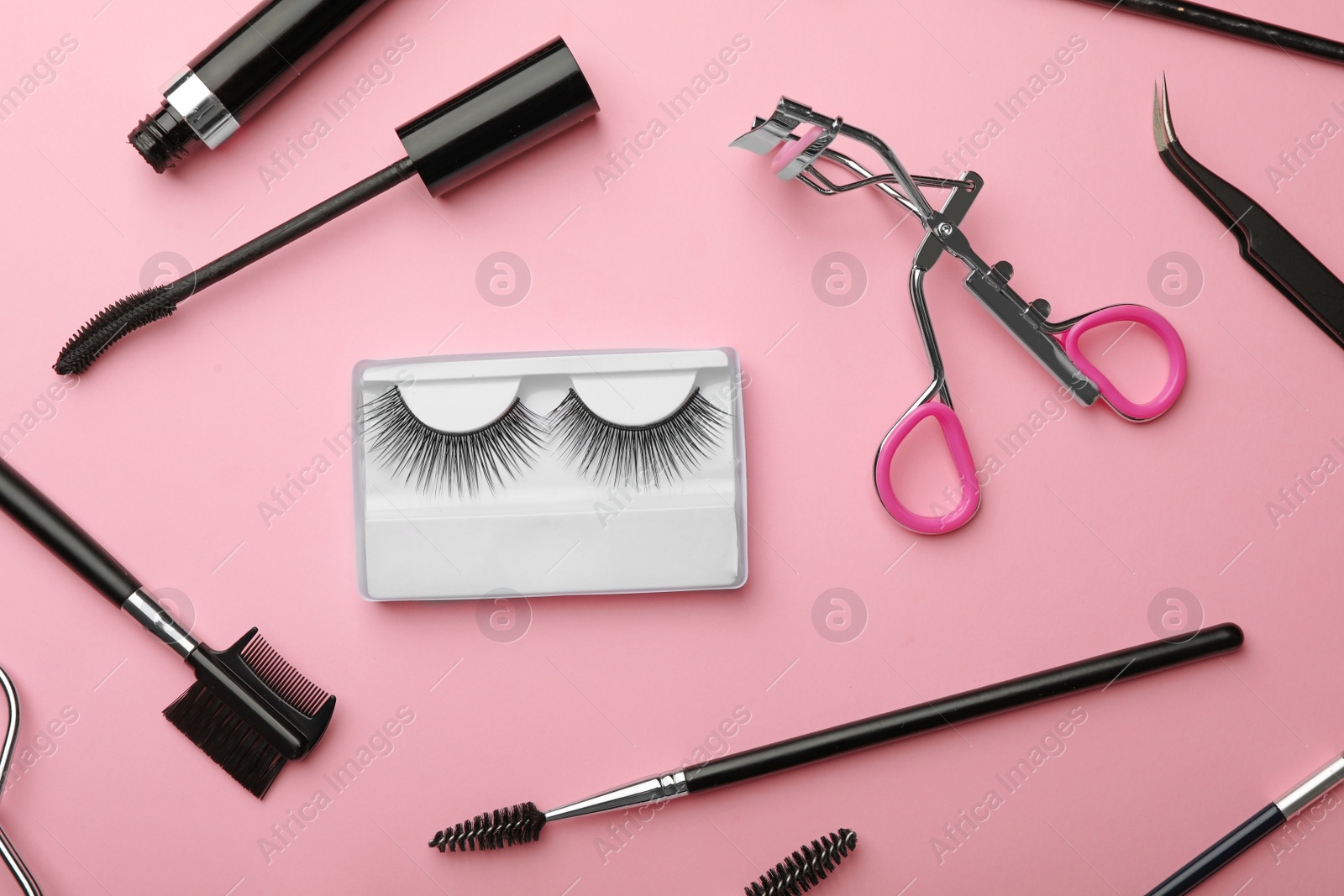 Photo of Flat lay composition of professional makeup tools and false eyelashes on color background