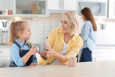 Photo of Mature woman, her grandchild and daughter spending time in kitchen
