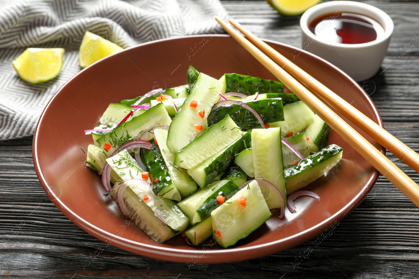 Photo of Plate with delicious cucumber salad on wooden table