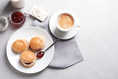 Tasty scones with clotted cream and jam on grey background, top view