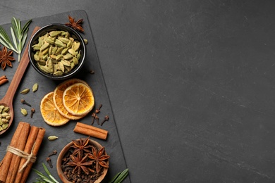 Flat lay composition with mulled wine ingredients on black slate table. Space for text