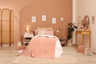 Photo of Teenage girl's bedroom interior with stylish furniture and beautiful decor elements