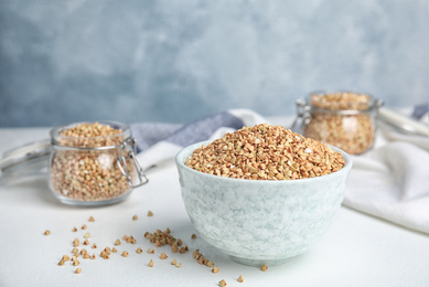 Photo of Bowl with green buckwheat on white table