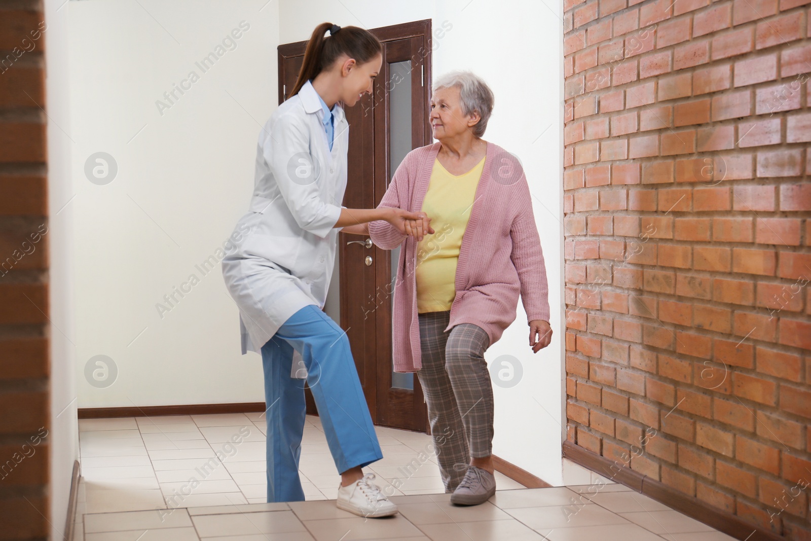 Photo of Doctor helping senior patient at modern clinic