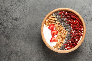 Smoothie bowl with goji berries on grey table, top view. Space for text