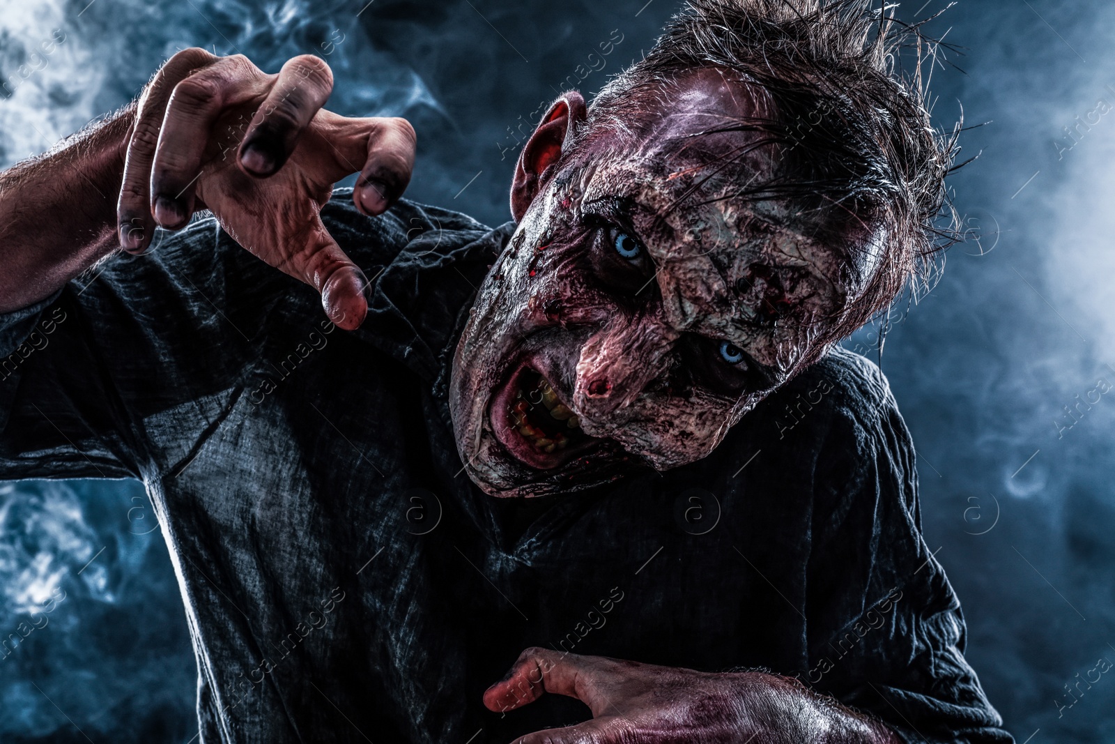 Photo of Scary zombie on dark background. Halloween monster