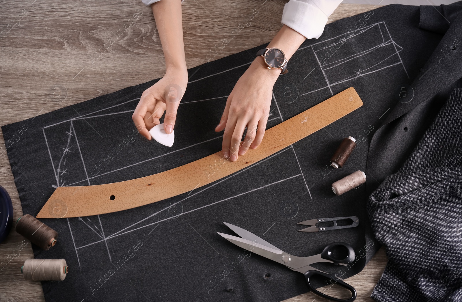 Photo of Tailor working at table in atelier, top view