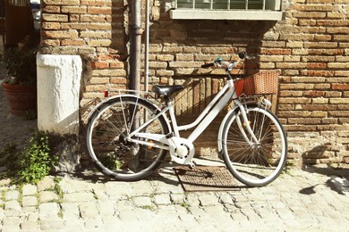 Bicycle with basket near building on sunny day